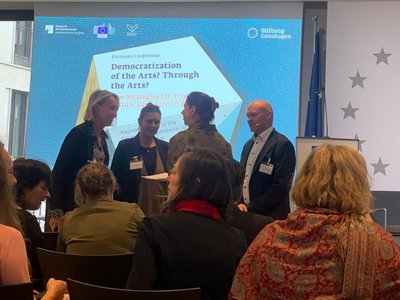 Eine Gruppe von Menschen versammelt sich vor einem Präsentationsbildschirm.