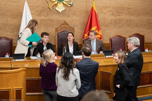 Menschen unterhalten sich im montenegrinischen Parlamentssaal