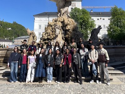 Group photo of scholarship holder standing in front of a statue in Salzburg