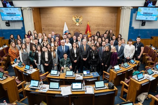 Ein Gruppenbild mit ca. 50 Menschen im montenegrinischen Parlamentssitzungssaal. Es sind meistens junge Menschen zu sehen.