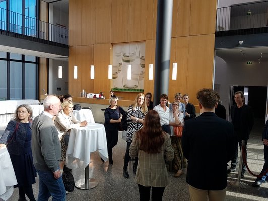 TeilnehmerInnan an Caféhaustischen im Foyer der Herta-Firnberg-Schulen