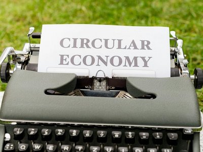 altmodische Schreibmaschine mit eingelegtem Papier. Darauf steht "Circular Economy".