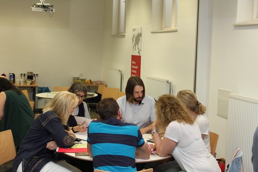 Menschen arbeiten beim Tisch.