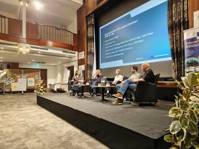Gabriele Bauer, EU-Programm-Officer für Erasmus+ Schulbildung, Karin Samek,  Erasmus+ Koordinatorin der Mittelschule In der Krim, Karin Zunzer, Direktorin der GTVS Wehlistraße, Daniel Attia vom Programm Seitenwechsel und Sebastian Beer Projektleiter von ESF+ "Construct" sitzen bei einer Gesprächsrunde auf der Bühne